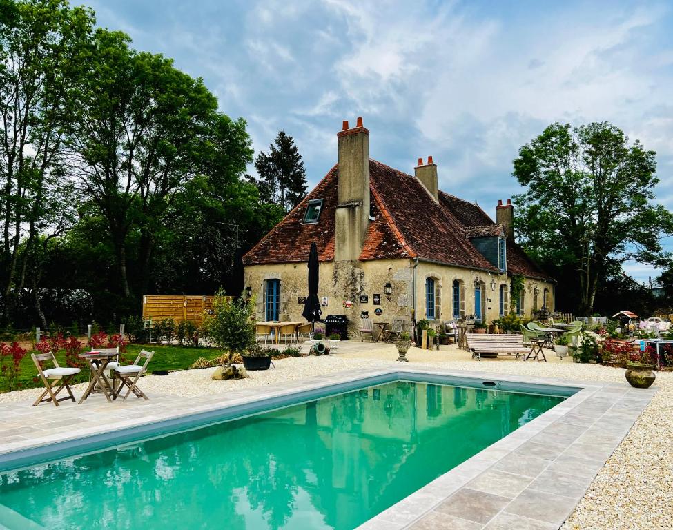 an estate with a swimming pool in front of a house at Le Presbytere de Leyrat 