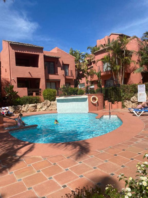 a swimming pool in front of a house at Don Carlos Marbella Beach in Marbella