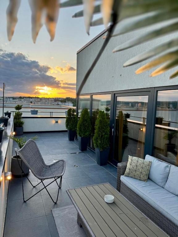a balcony with a couch and a table on a building at PENTHOUSE EXCLUSIVE VIEW , Iasi in Iaşi