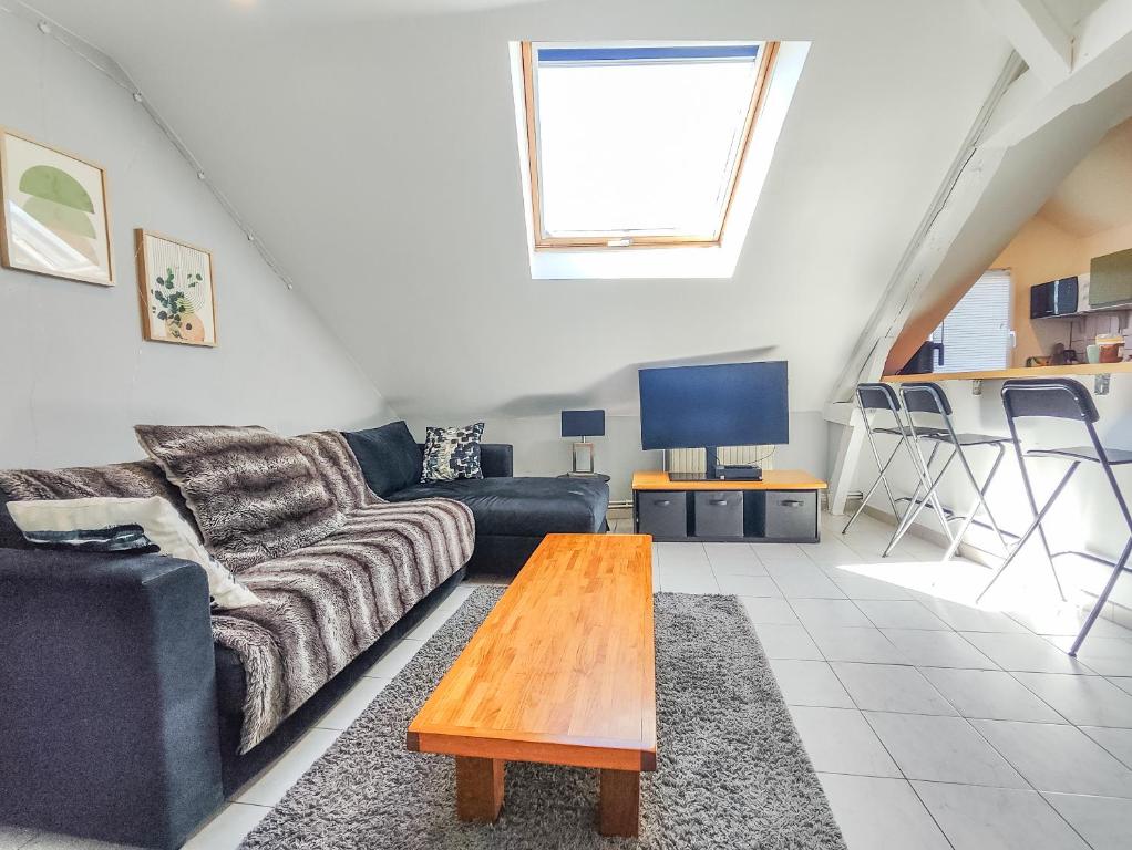 un salon avec un canapé et une table dans l'établissement Le Havre Sanvic - appartement chaleureux, au Havre
