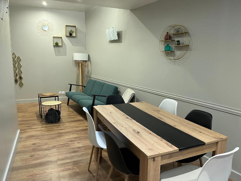 a dining room with a table and a couch at Appartement cosy parking idéal JO 2024 in Le Bourget