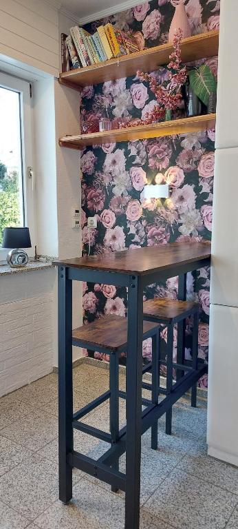 a table in a room with flowers on the wall at Helle Ferienwohnung mit Garten und Terrasse, direkt am Waldrand gelegen in Herzogenrath