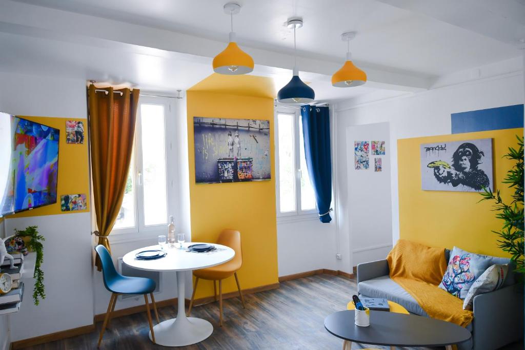 un salon avec une table et un mur jaune dans l'établissement Le Banksy, à La Seyne-sur-Mer