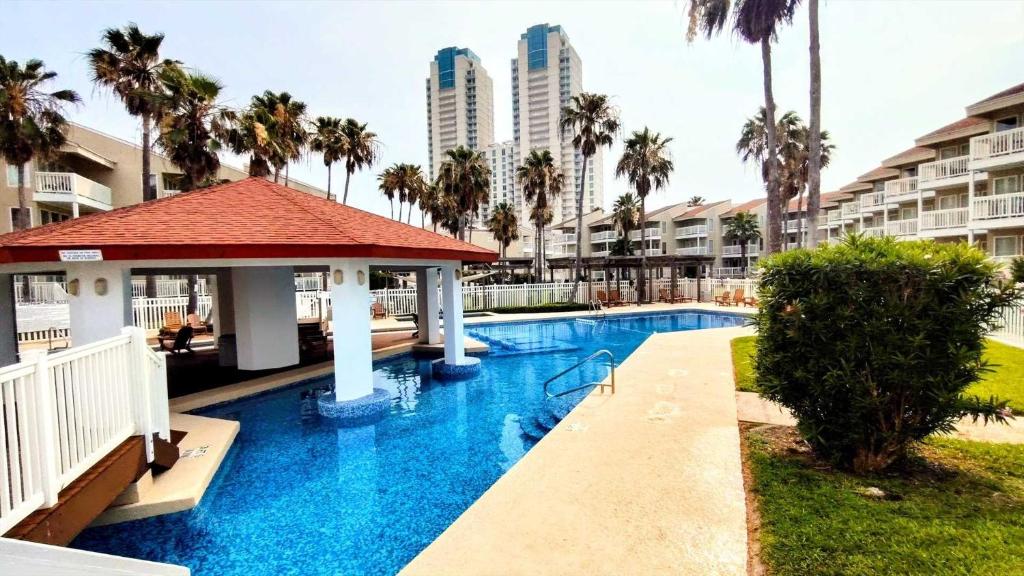 a pool at a resort with palm trees and buildings at Gulfpoint 3209 in South Padre Island