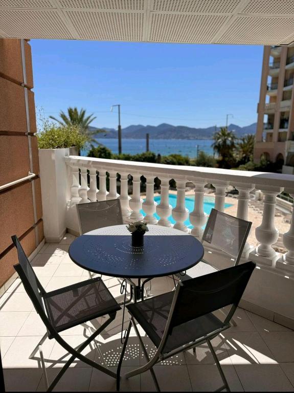 une table et des chaises sur un balcon avec vue dans l'établissement Cannes appartement vue mer , piscine, à Cannes