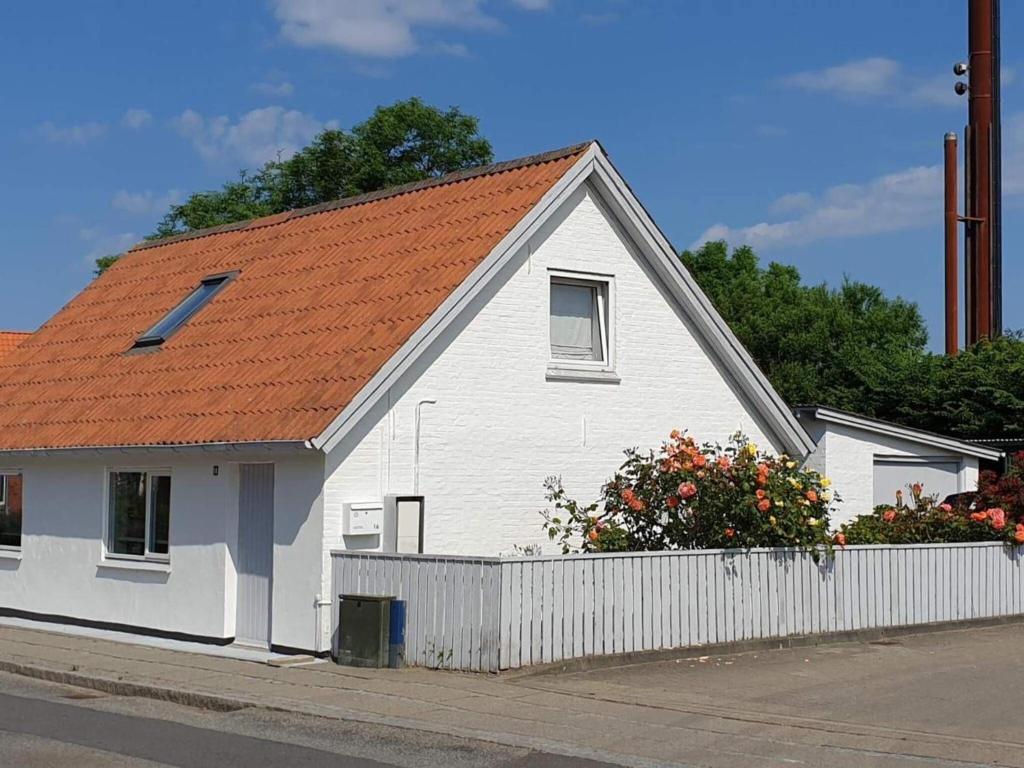 a white house with an orange roof and a fence at Holiday home Vestervig XLIX in Vestervig