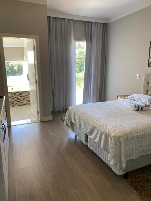 1 dormitorio con cama y ventana grande en Casa de campo espetacular condomínio a 50min de SP en Itupeva