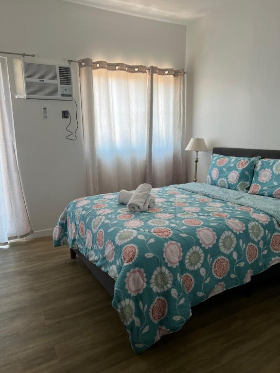 een slaapkamer met een bed met een dekbed en een telefoon bij Antara Condominium Residences in Talisay