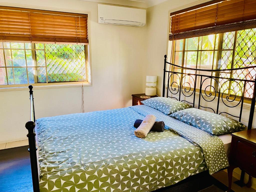 a bedroom with a bed and two windows at Granny flat in Brisbane