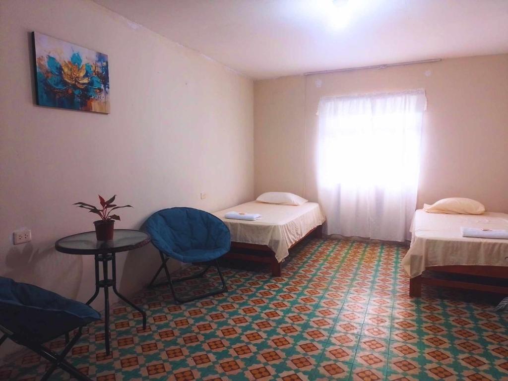 Cette chambre comprend 2 lits, une table et une fenêtre. dans l'établissement hotel Suyay Lodge Tarapoto, à Tarapoto