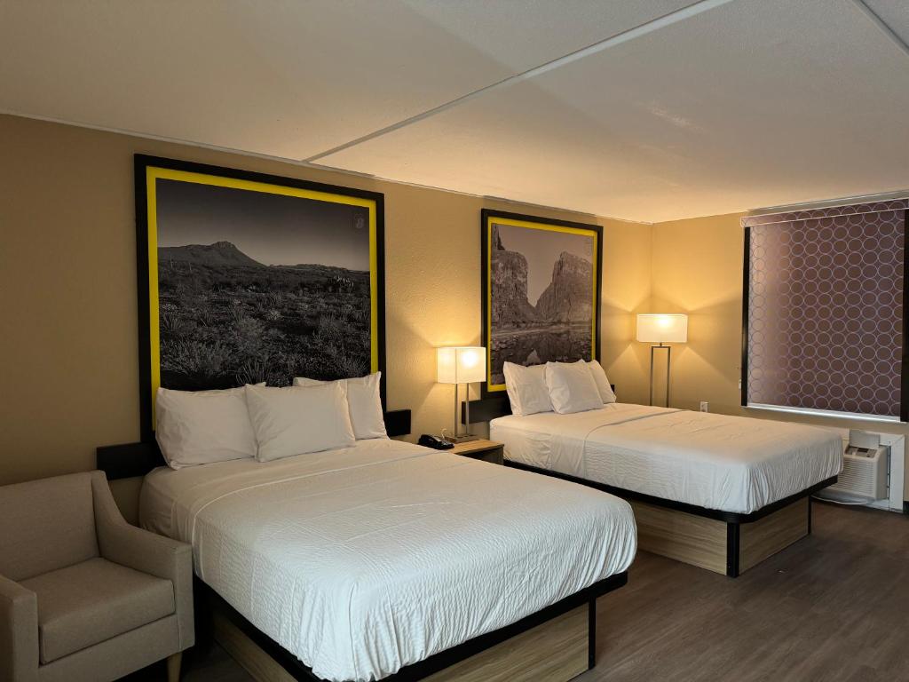 una habitación de hotel con 2 camas y una silla en Super 8 by Wyndham Corpus Christi Airport en Corpus Christi