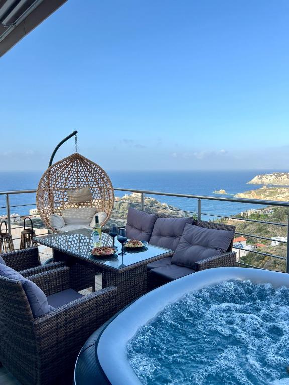 a hot tub on a balcony with a view of the ocean at OMG in Agia Pelagia