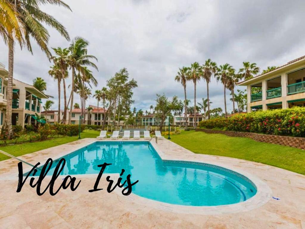 una piscina en una villa con palmeras en Villa Iris 2 story ocean view villa w/ pool access, en Vega Alta