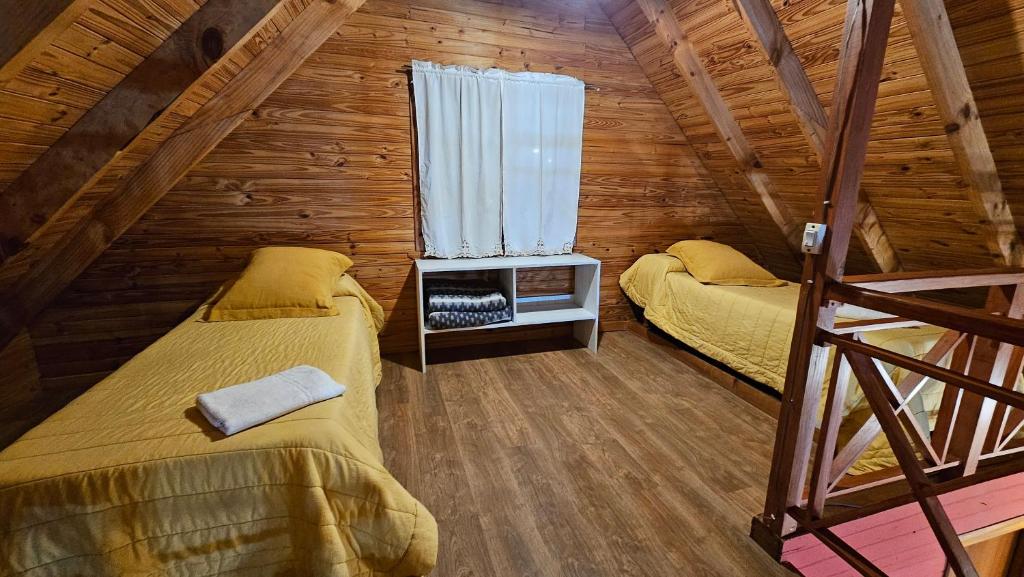 1 dormitorio con 2 camas en una cabaña de madera en Entre montañas en San Carlos de Bariloche