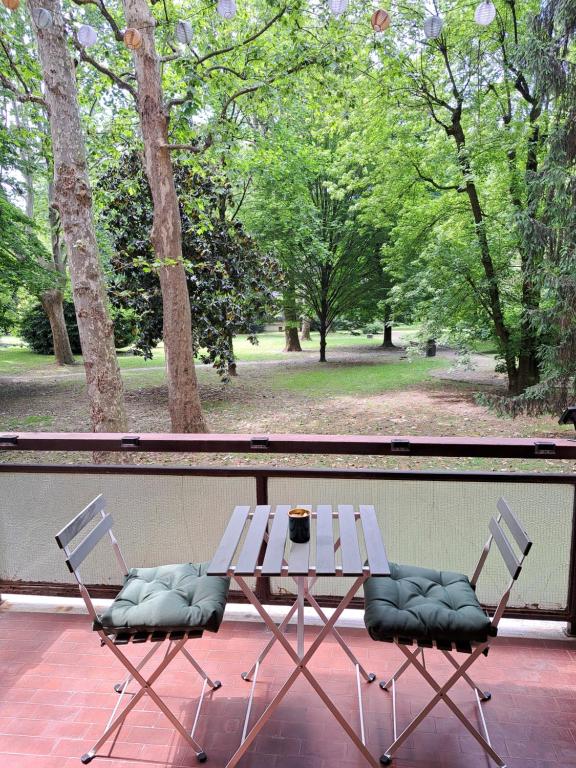- une table de pique-nique et 2 chaises sur une terrasse couverte dans l'établissement IL BALCONE NEL PARCO - stanze con bagno privato, à San Donato Milanese