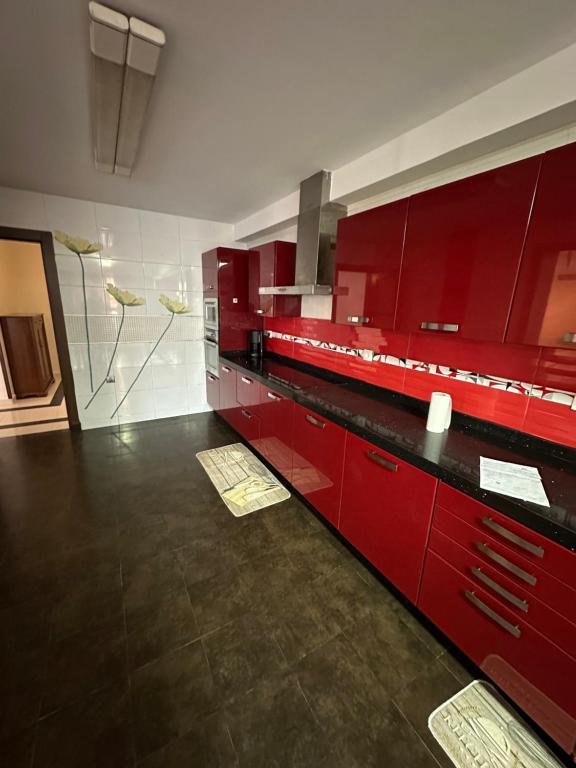 a kitchen with red cabinets and a black counter top at Sidi Mhamed mobilart in Oran
