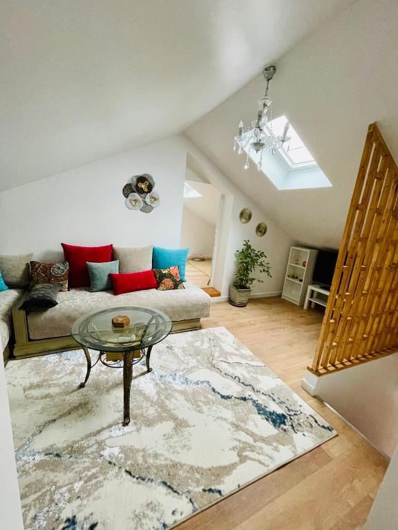un salon avec un canapé et une table en verre dans l'établissement Appartement charmant et lumineux, à Villejuif