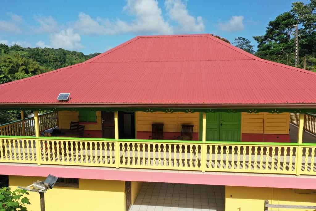 a house with a red roof at Le gîte du jardin in Gros-Morne
