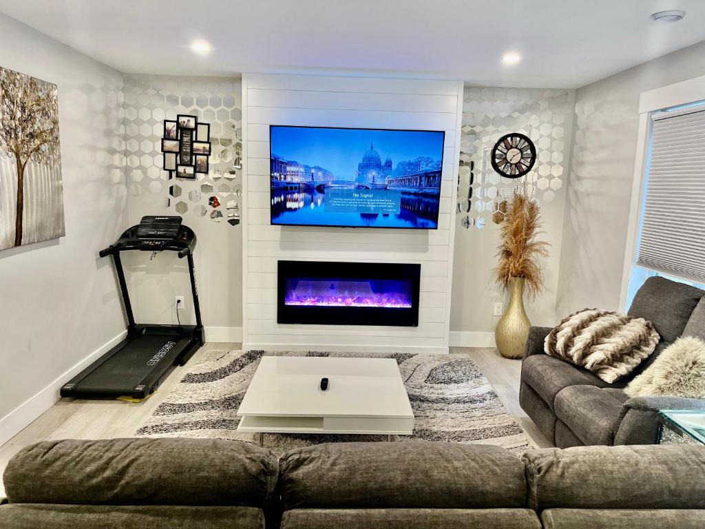 uma sala de estar com um sofá e uma televisão de ecrã plano em New built home, A/C, close to airport em Dieppe