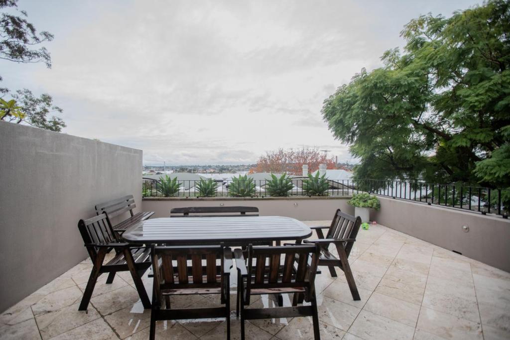een patio met een tafel en stoelen op een balkon bij PHOE1-3B - Harbour Haven Townhouse in Sydney