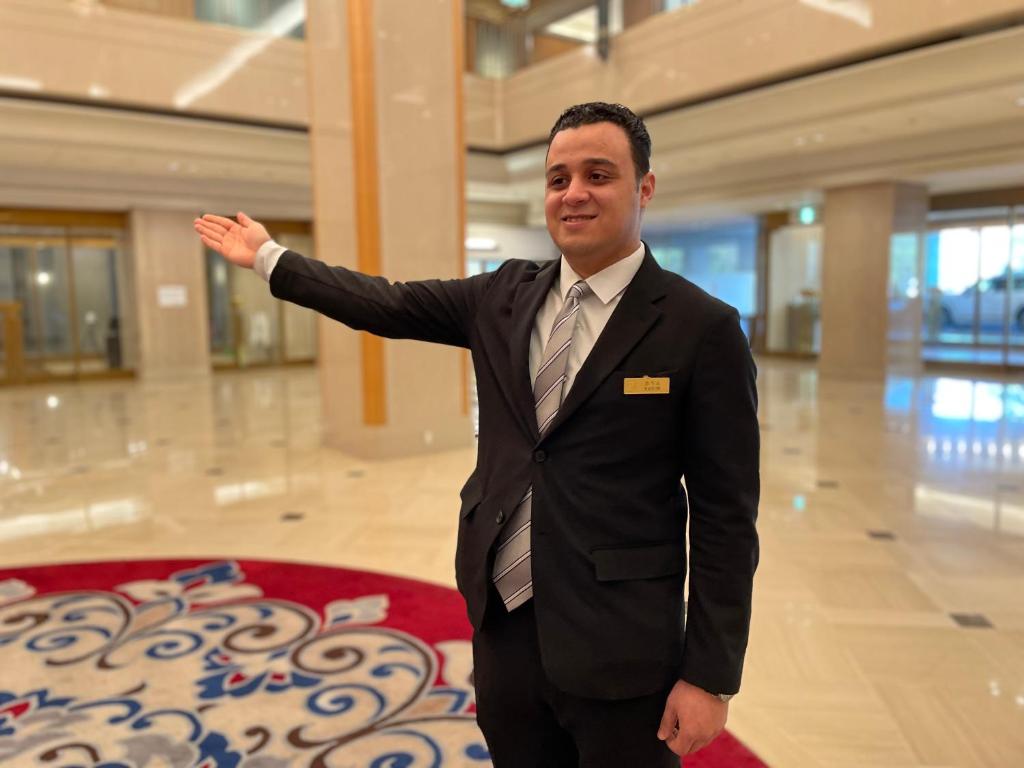 a man in a suit and tie standing in a building at Rihga Royal Hotel Hiroshima in Hiroshima