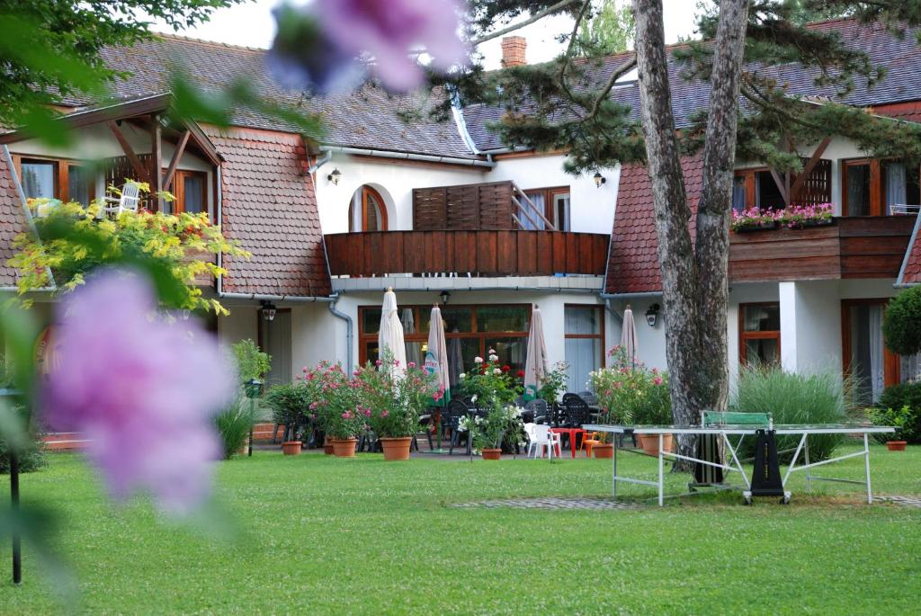 a house with a garden and a table in the yard at Hotel Kentaur in Siófok