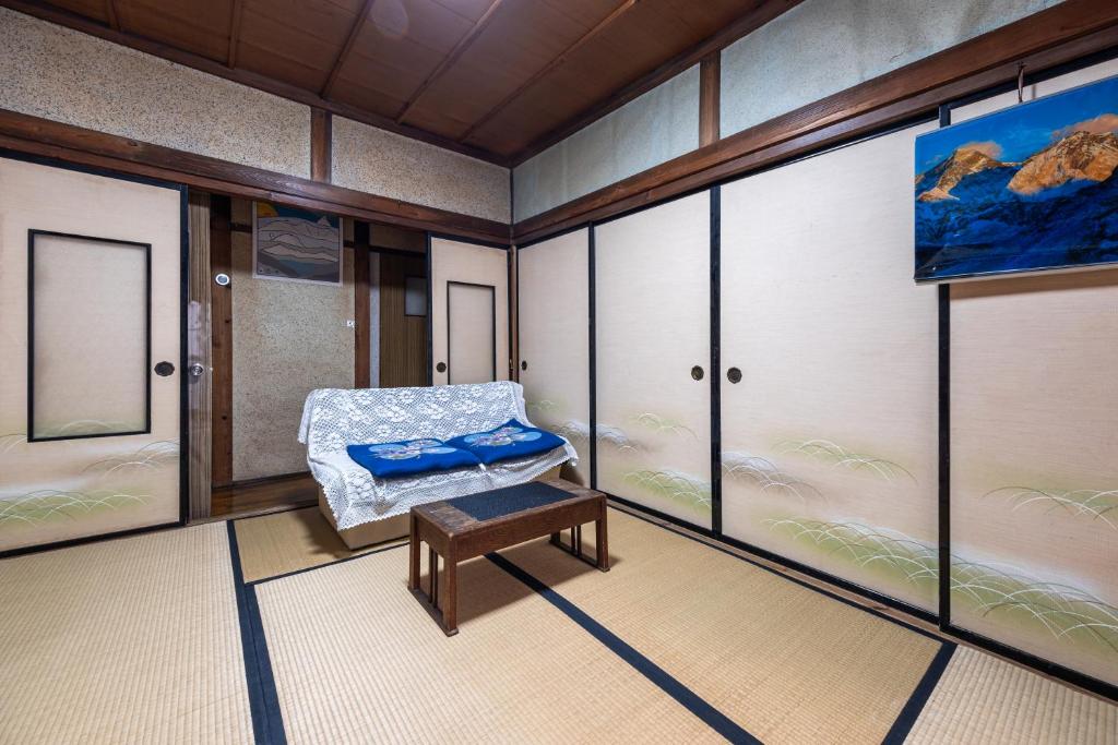 松本市にあるHostel みんか松本の椅子とテーブル、窓が備わる客室です。