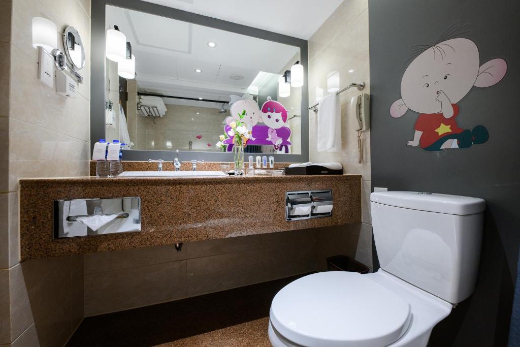 a bathroom with a toilet and a sink with a mirror at Crowne Plaza Shanghai by IHG in Shanghai