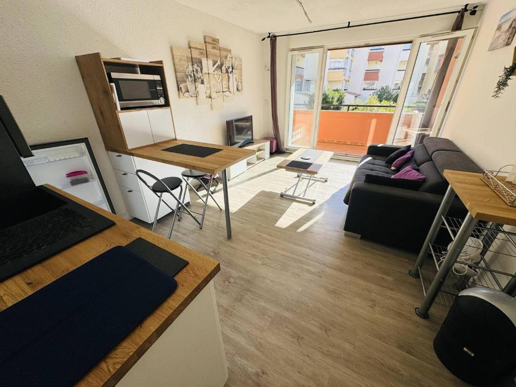 un petit salon avec un canapé et une table dans l'établissement Appartement rénové près du port avec parking privatif - FR-1-723-156, au Cap d'Agde