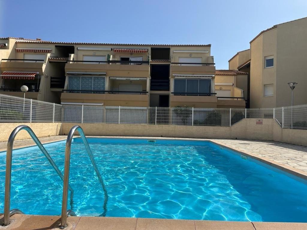 une piscine devant un immeuble dans l'établissement Studio Cabine avec Piscine, Terrasse et Parking, Proche Commodités - FR-1-387-206, à Marseillan