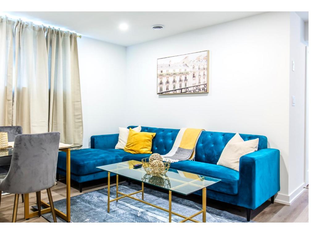 New Luxury Suite 6Mins To Falls, Free Parking في شلالات نياجارا: غرفة معيشة مع أريكة زرقاء وطاولة