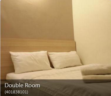 a bed with white pillows in a room at Hotel18 in Ipoh