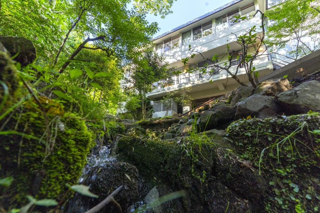 a building with a waterfall in front of a building at koti hakone（コティ箱根） in Hakone
