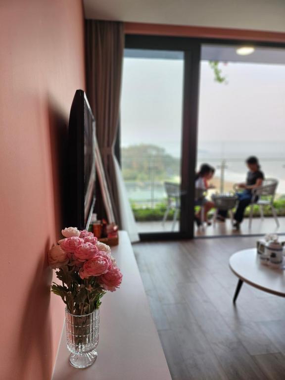 een vaas met bloemen op een tafel in een woonkamer bij Flamingo Hải Tiến in Nam Khê