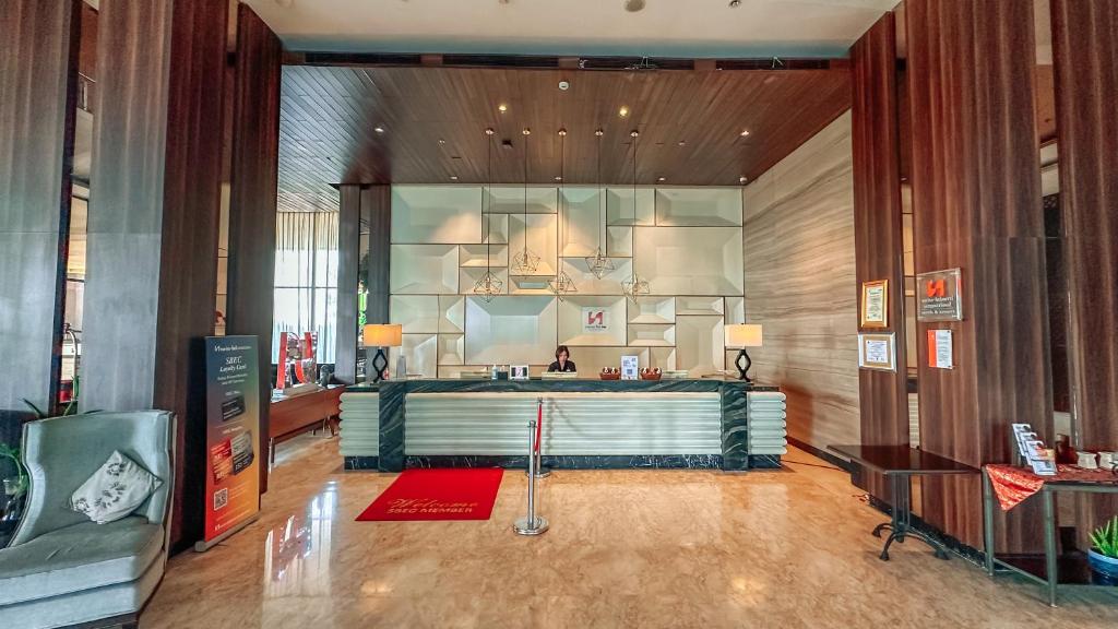 a lobby with a reception desk in a building at Swiss-Belinn Karawang in Karawang
