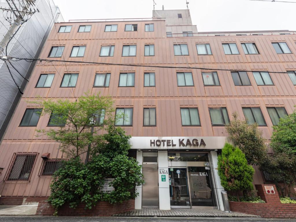 un gran edificio de ladrillo rojo con un koya hotel en Business Hotel Kaga, en Osaka