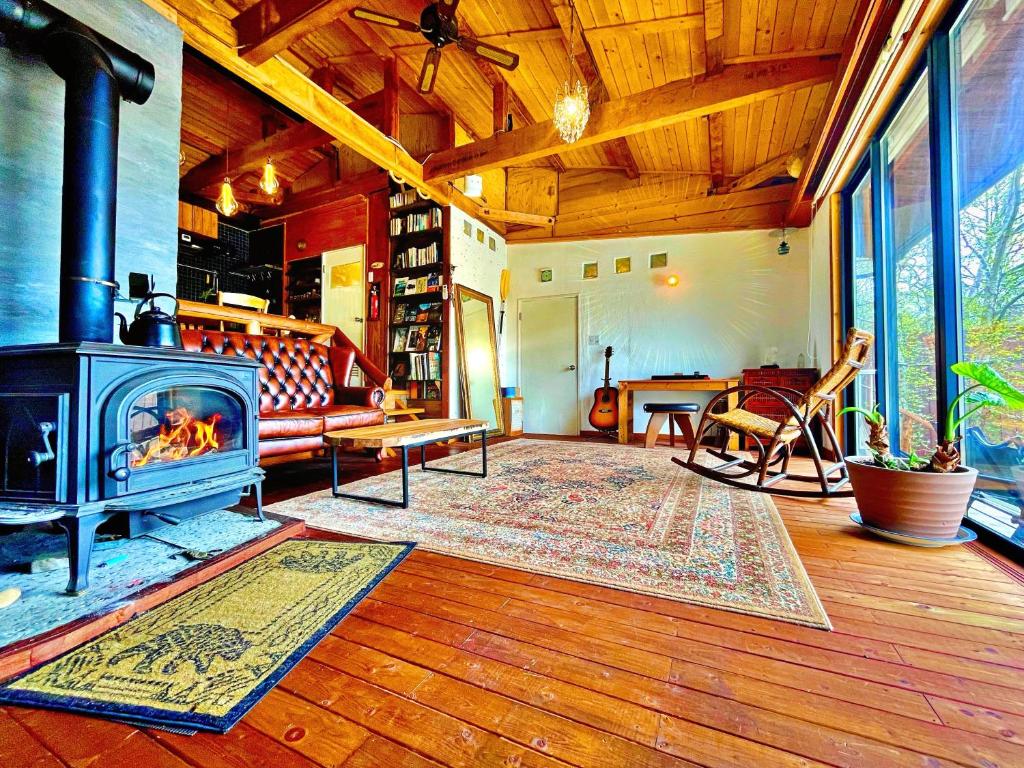 sala de estar con chimenea y sofá en New Open!SHIZENTOYA Privete cottage for nature experience LakeView!, en Sobetsu