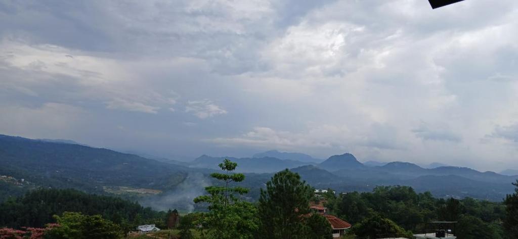 a view of a valley with mountains in the distance at Ama Residency & Homestay Kandy in Hindagala