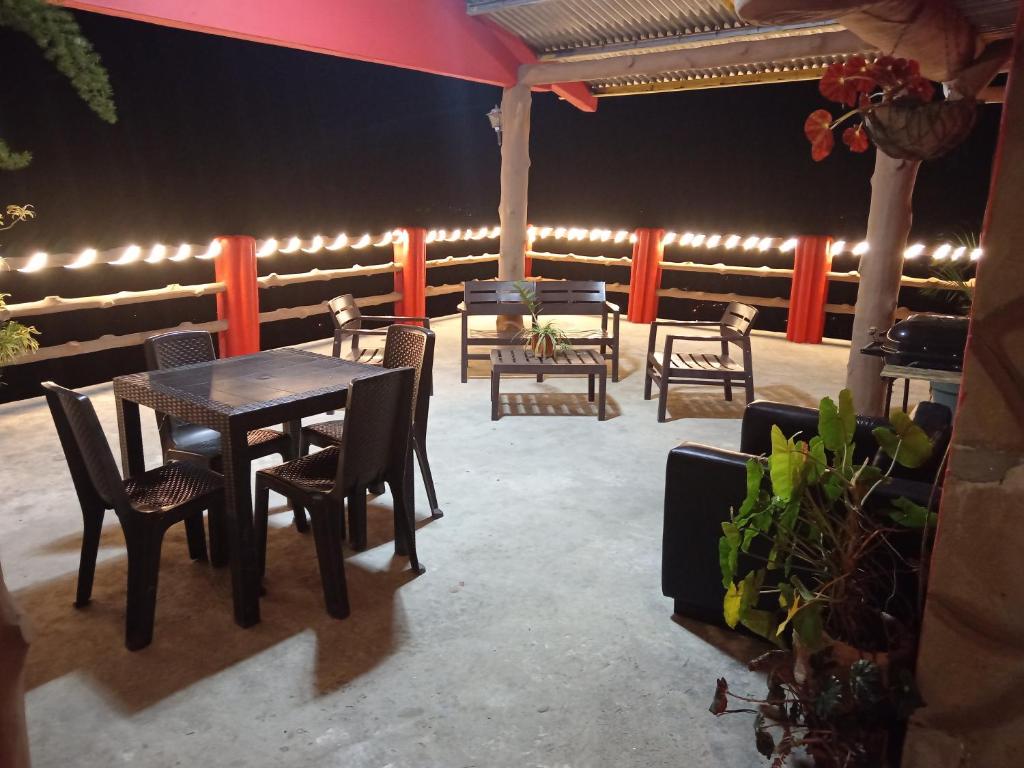 un patio con tavoli, sedie e luci di Hostal familiar Bajo las estrellas a Chame