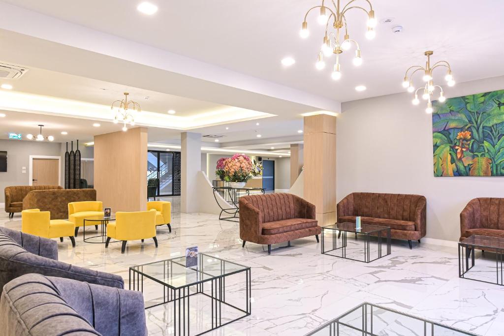 A large open lobby furnished with colourful armchairs and several sofa areas.