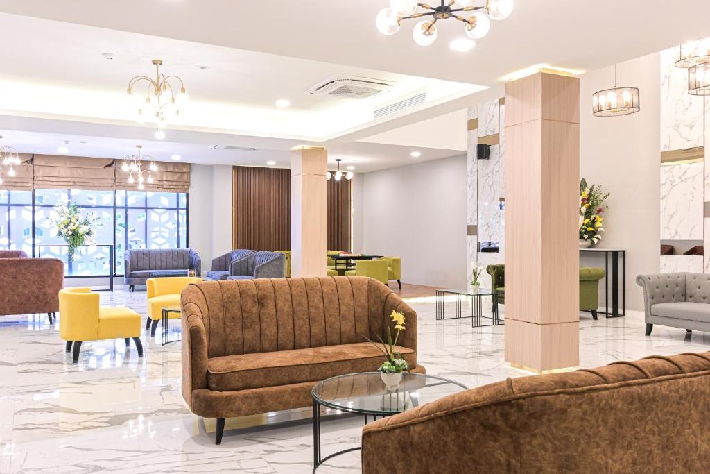 An expansive lobby with multiple seating areas, columns and bright lighting.