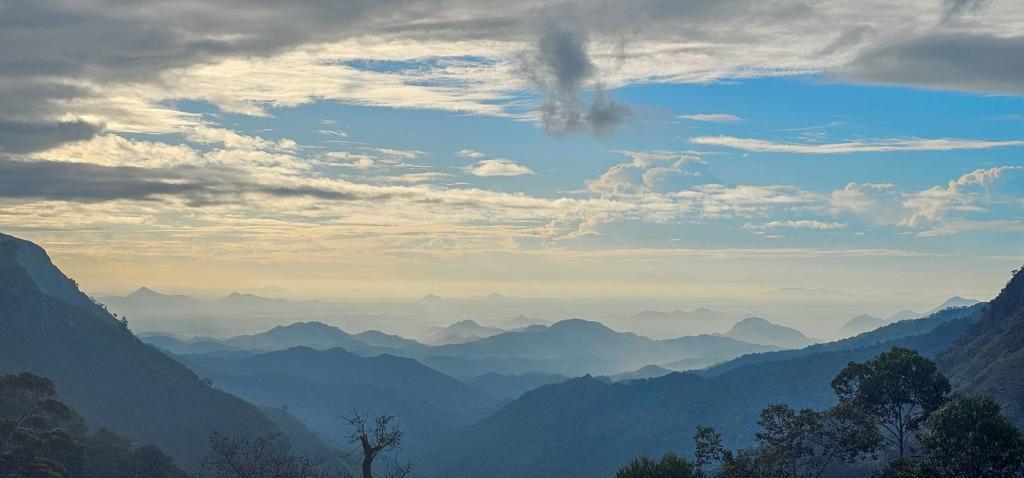 a view of a mountain range with a cloudy sky at Hilltop Guest House in Ella
