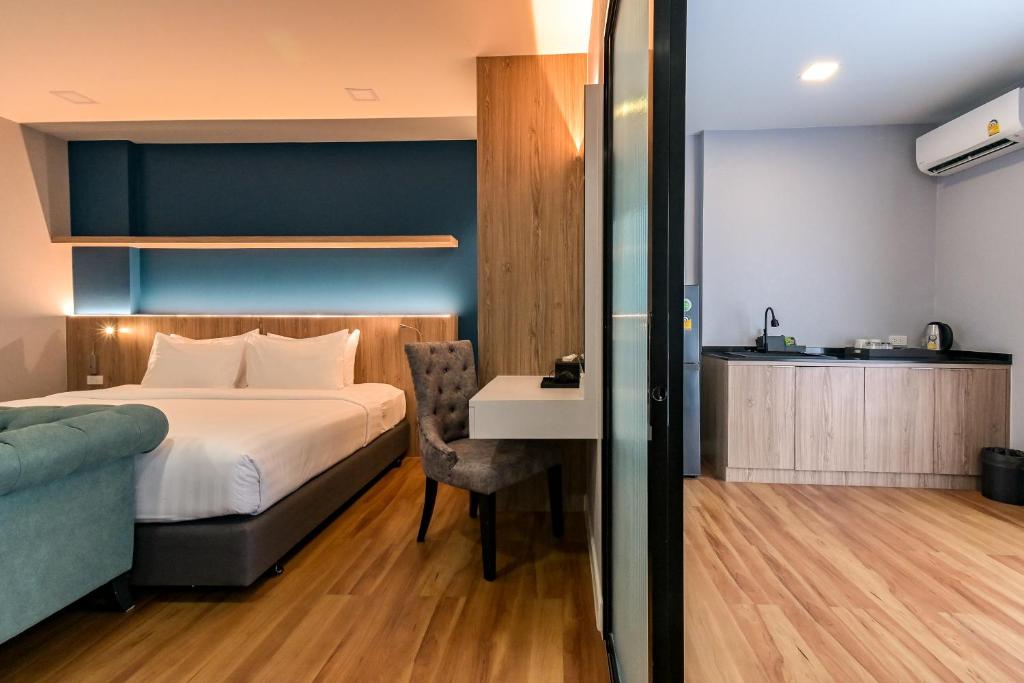 A room-wide view linking the bed, sofa, desk, kitchenette, and air conditioner.