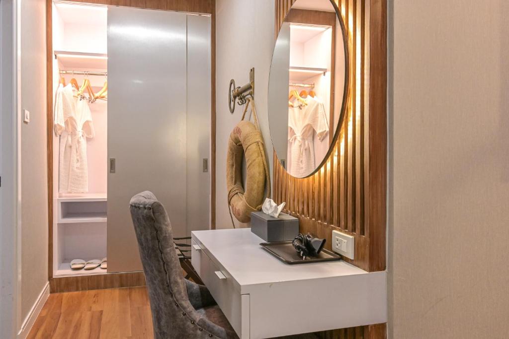 A built-in dressing and work area with a narrow desk, mirror and open wardrobe.