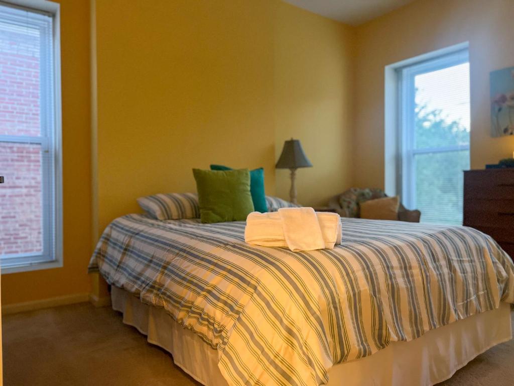 1 dormitorio con 1 cama con almohadas verdes en Mon Fournissuer 4bd Home with backyard, en Louisville