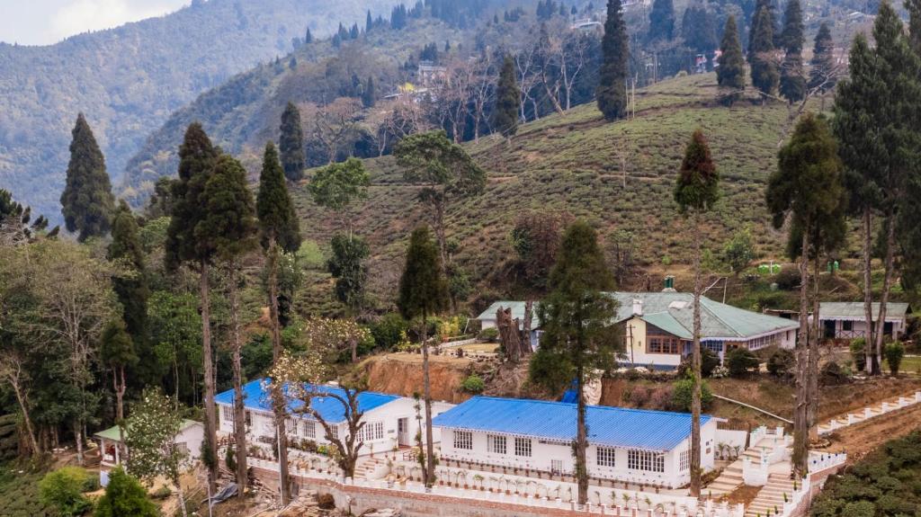 a house with a blue roof on a mountain at Chhota Haazri, By The Rajbari Bawali in Darjeeling