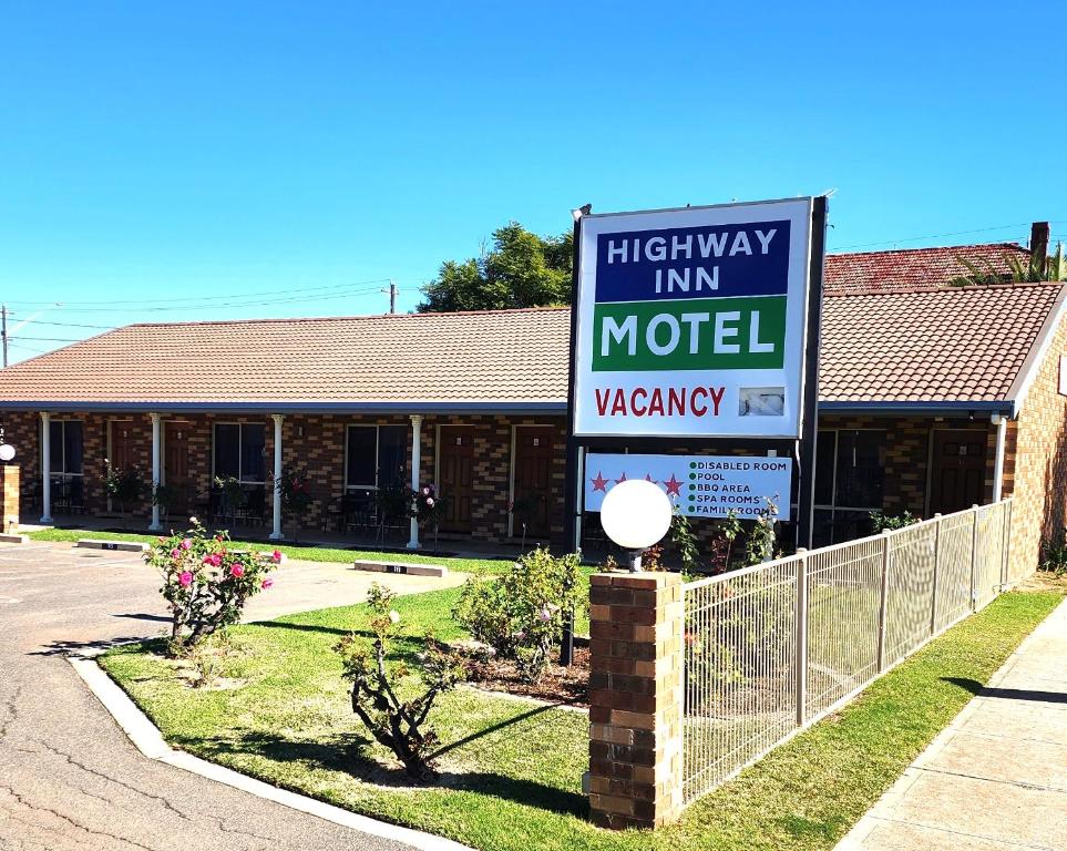 - un panneau indiquant une auberge en hauteur devant un bâtiment dans l'établissement Highway Inn Motel, à Hay