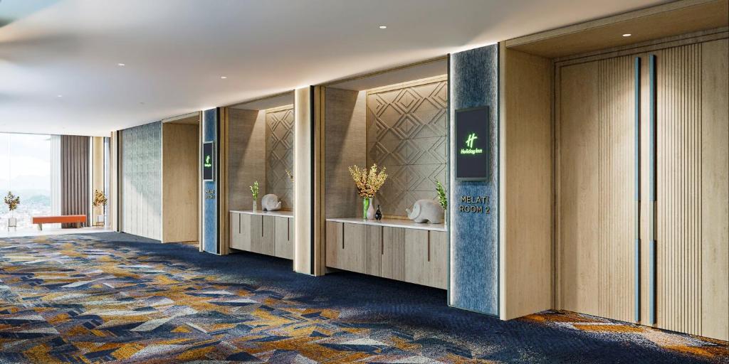 un pasillo de un hotel con un vestíbulo con puertas de cristal en Holiday Inn Lampung Bukit Randu, an IHG Hotel en Bandar Lampung