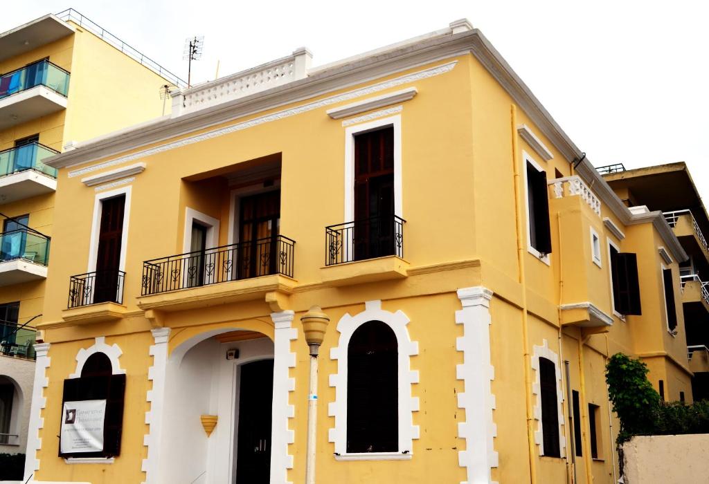 a yellow building with two balconies on it at City center beach house in Rhodes Town