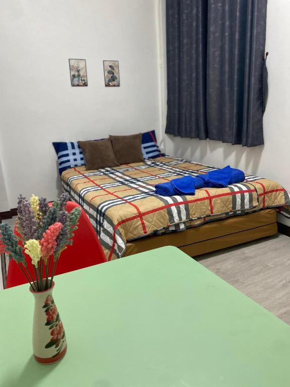 a room with a bed and a table with a vase with flowers at Colibri Inn in Thong Sala